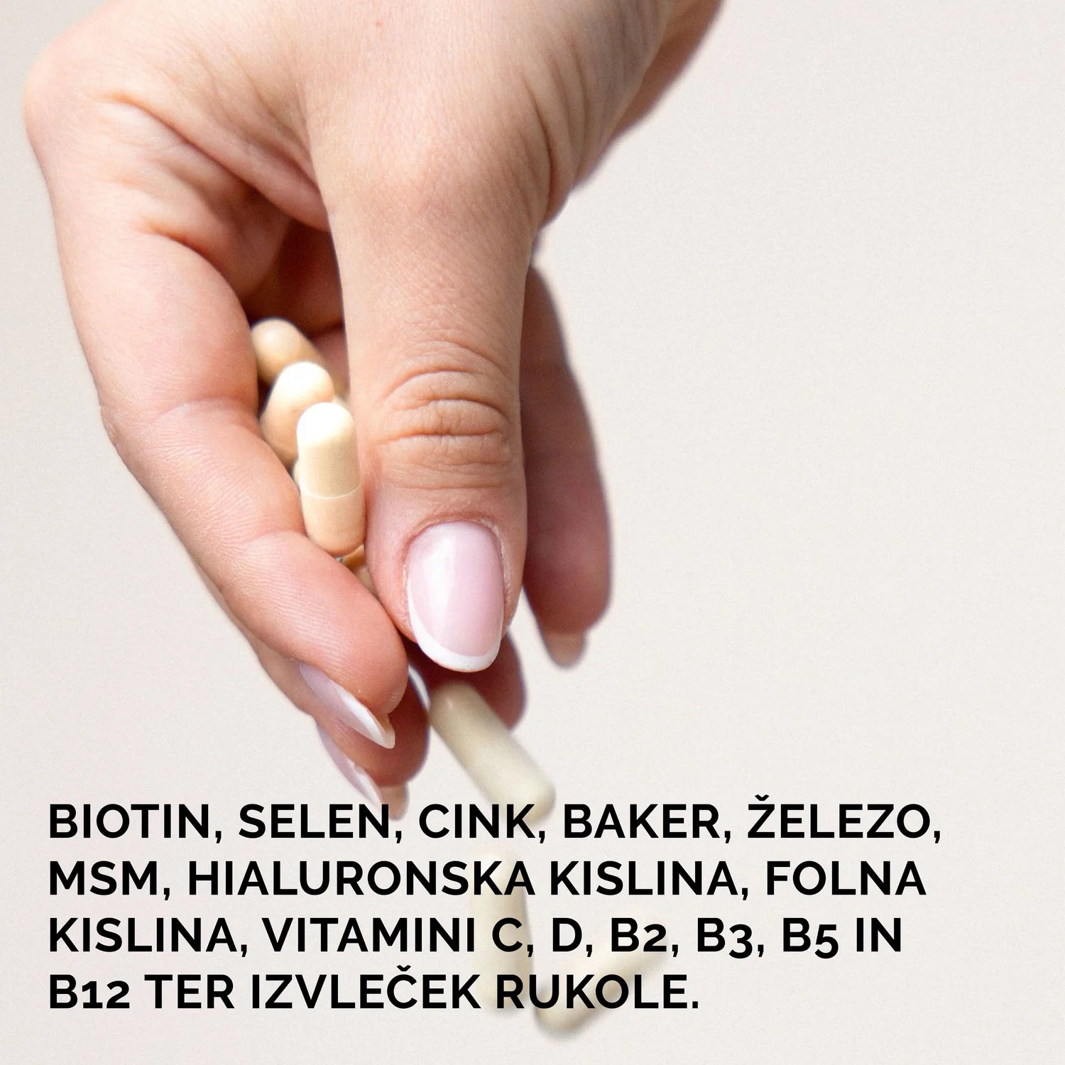 Roka drži Elixiré Hair Fusion kapsule — biotin, selen, cink, baker, železo, MSM, hialuronska kislina, vitamini in izvleček rukole